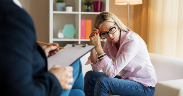 A depressed woman in a therapists office.