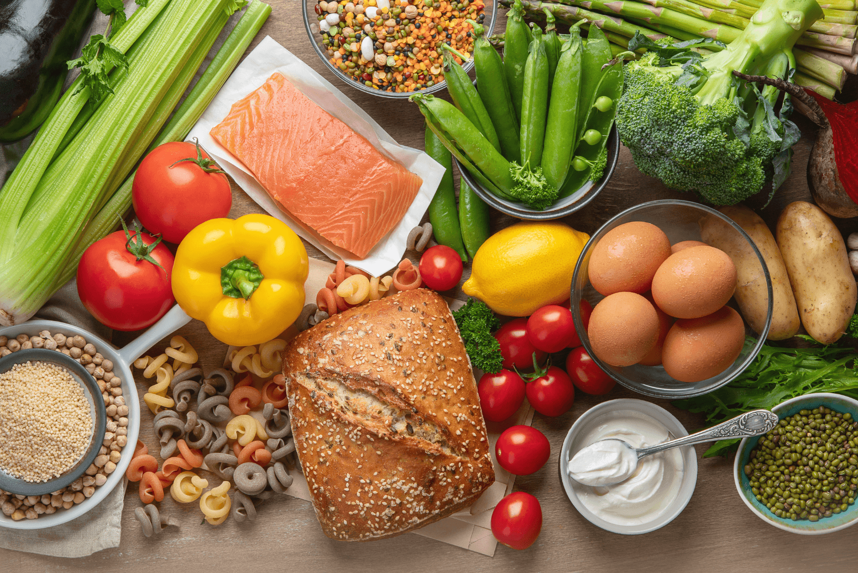 A picture of foods from the Mediterranean diet. The picture has flavorful foods like fish, greens, seeds, nuts and more.