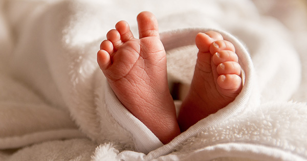 Baby's feet poking out of a blanket.